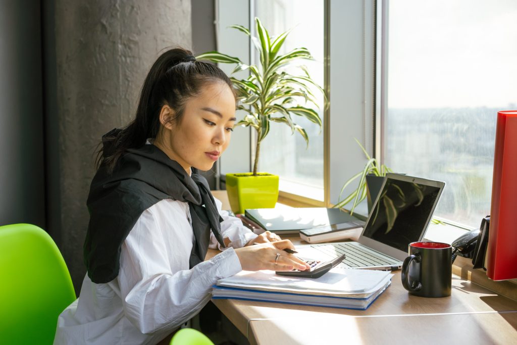 accountant working using her calculator and laptop