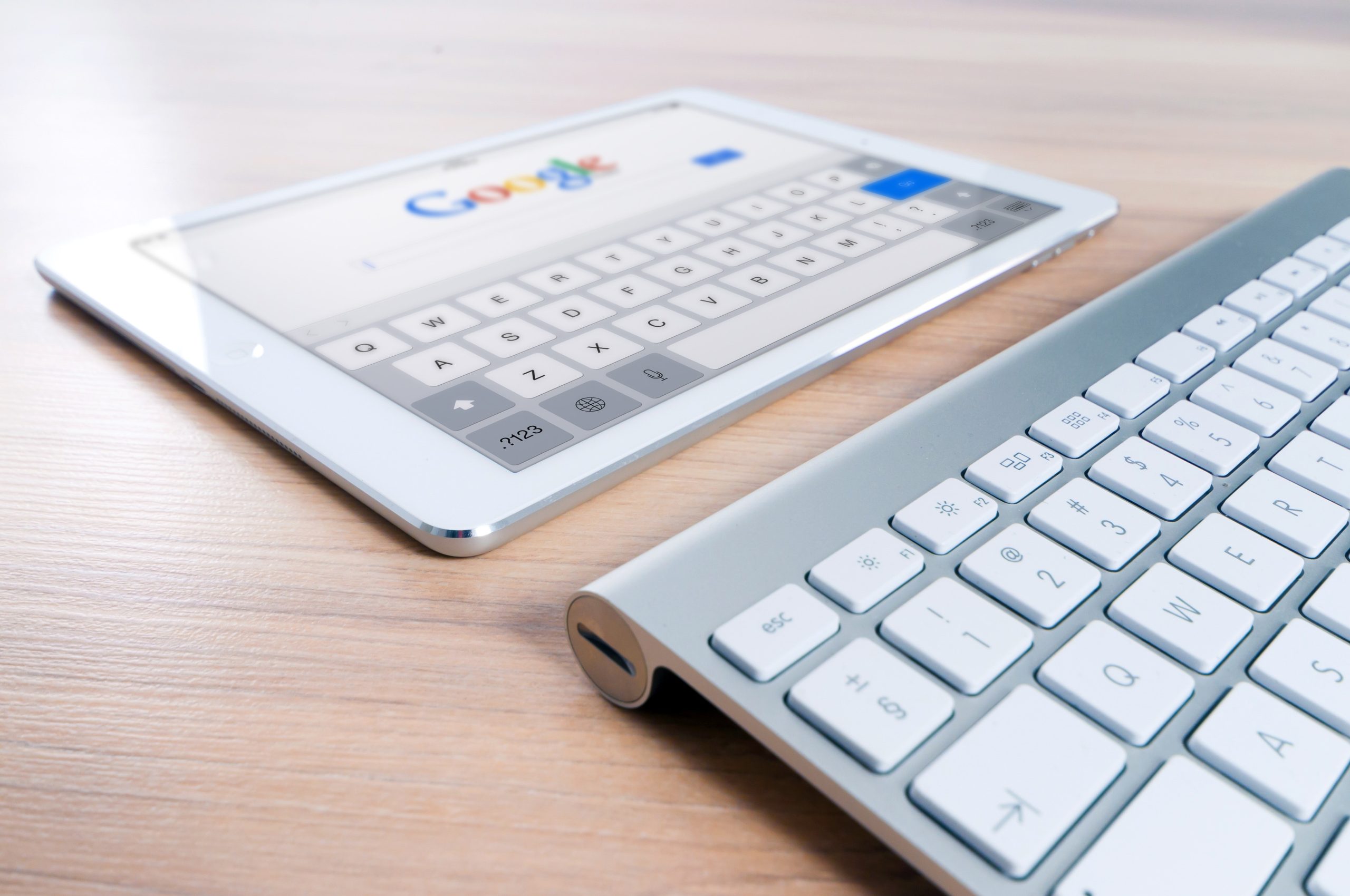 tablet and a keyboard on top of a wooden table