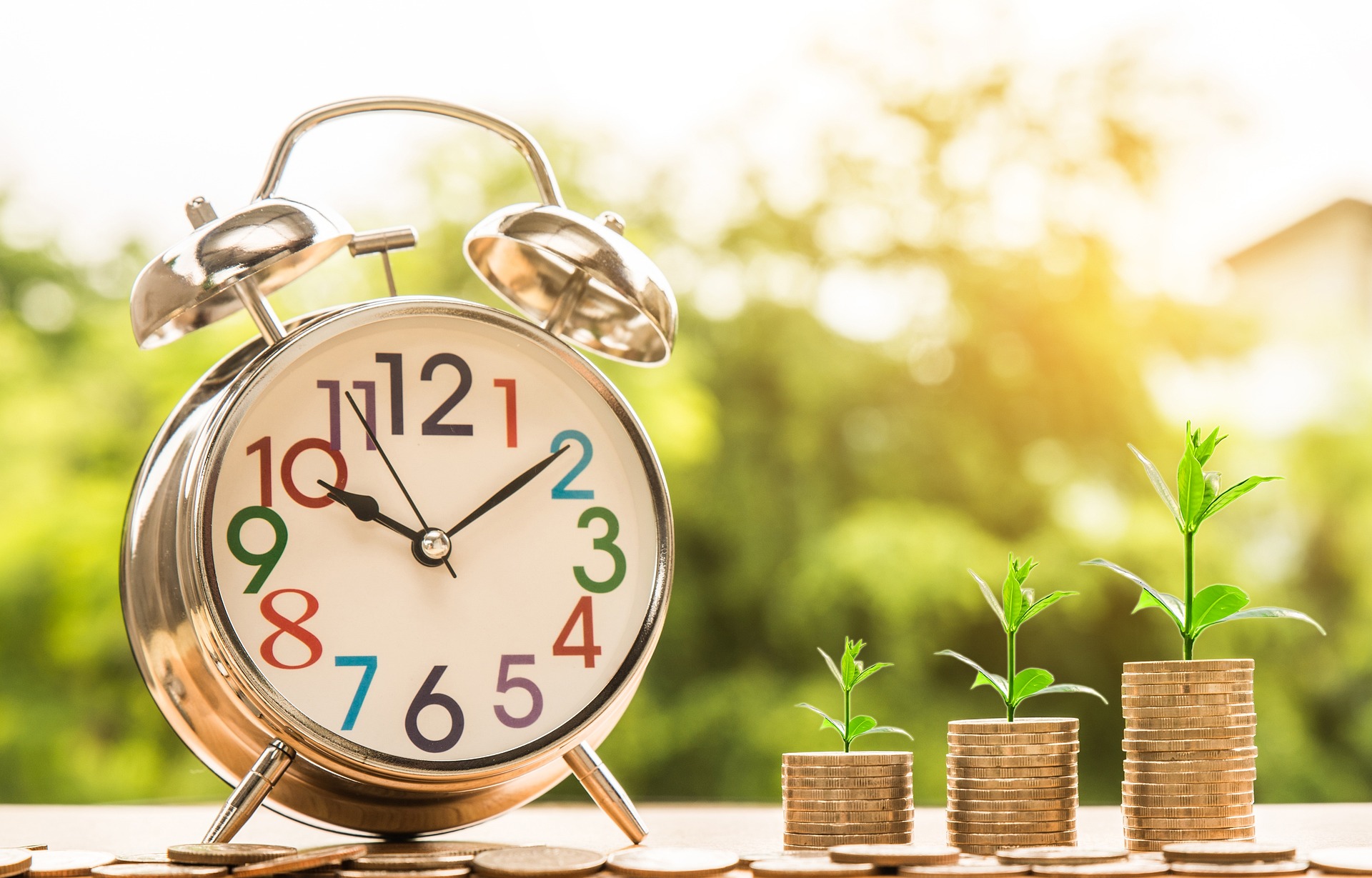 growing stack of coins beside a clock