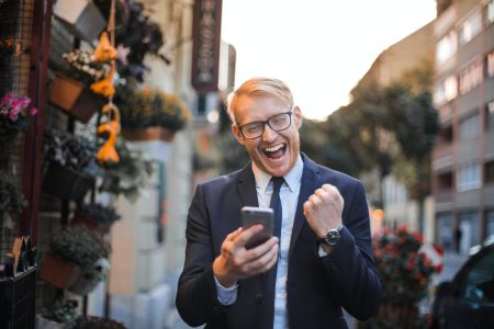 happy accountant while holding his mobile phone